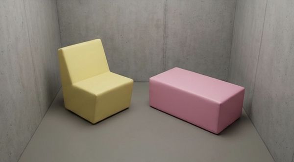 Gele gecoate stoel en roze poef in een betonnen ruimte – QMtex®, regio Menen