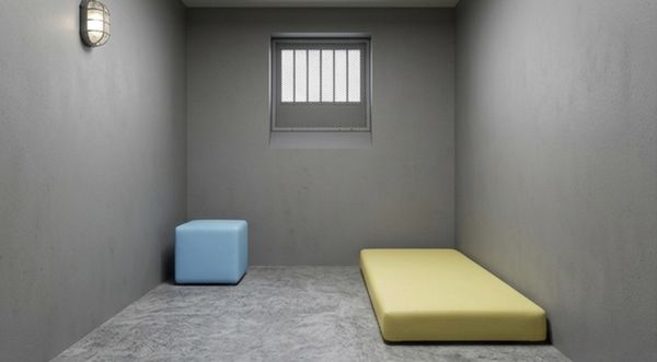 Blauwe gecoate kubus en gele matras in een ruimte met getralied venster – QMtex®, regio Anzegem
